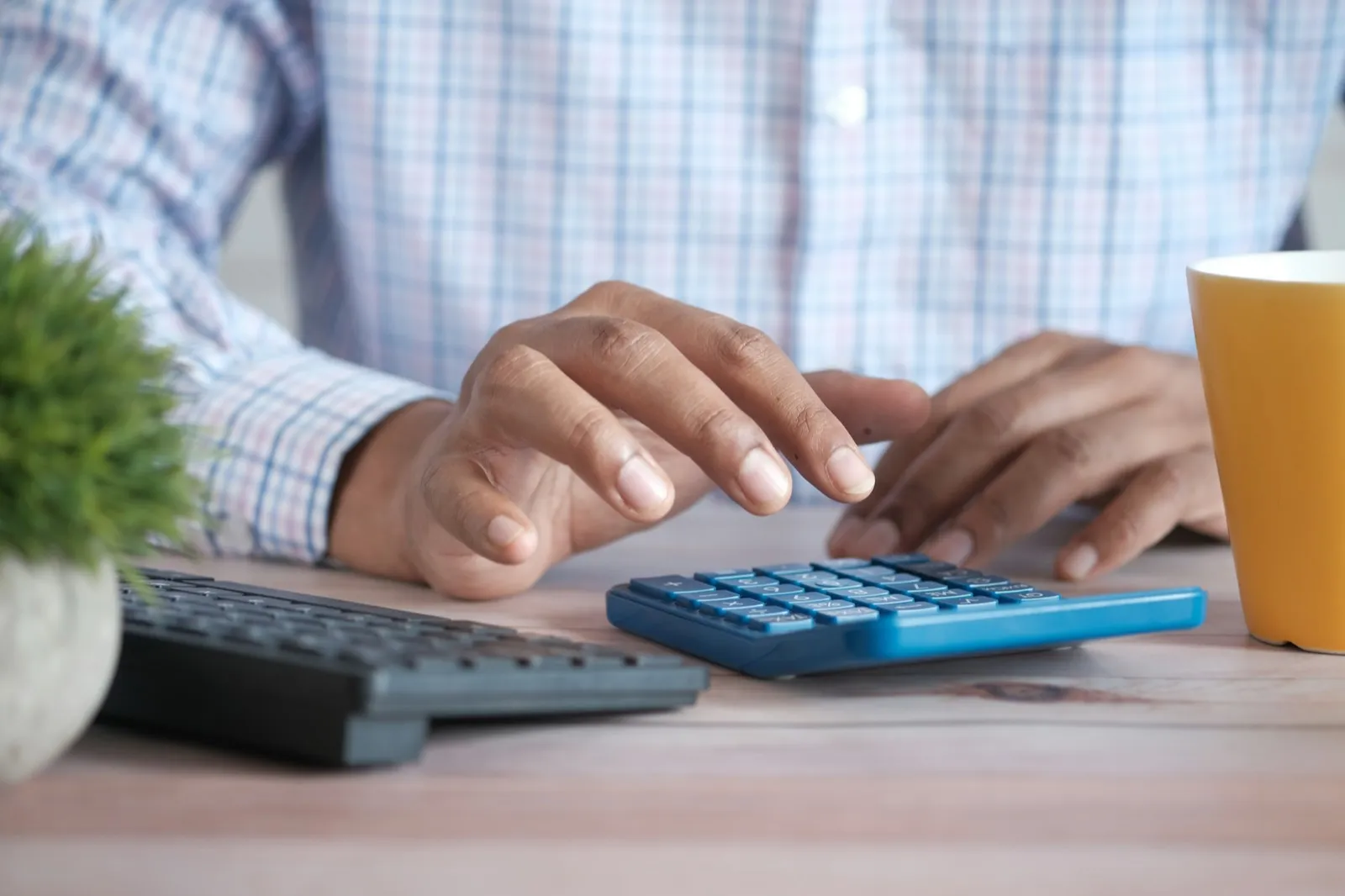 Contractor running job numbers on a calculator at a desk
